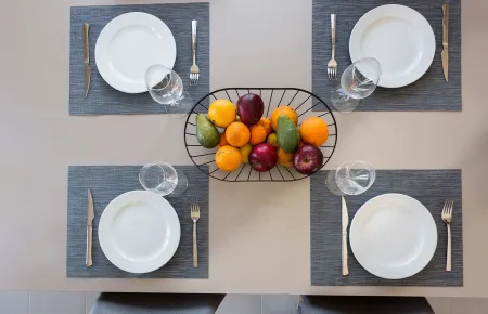  Dining table with plates, cutlery and fruits
